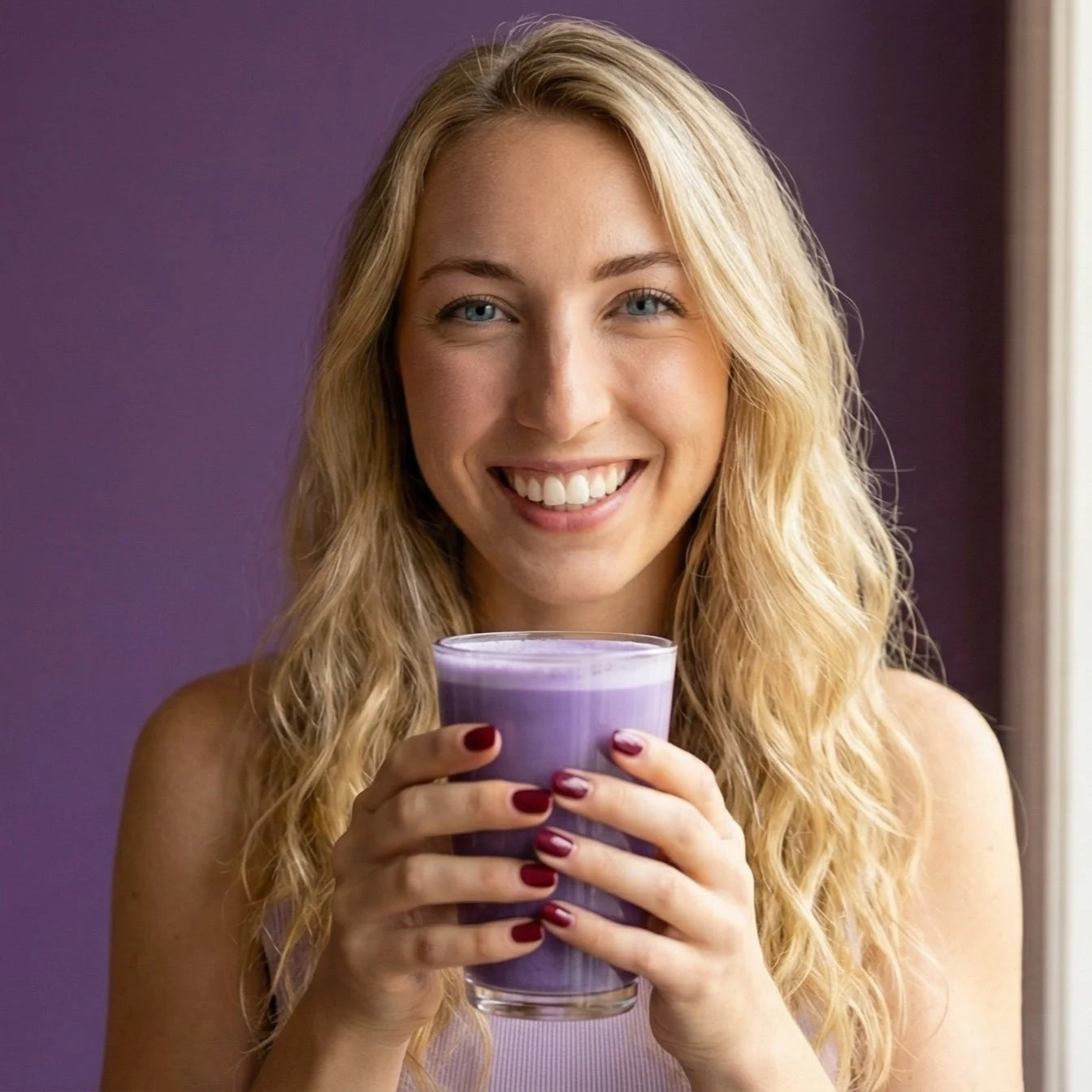 Femme souriante profitant de son latte à l'Ube MyUbe, le rituel gourmand qui remplace le café.